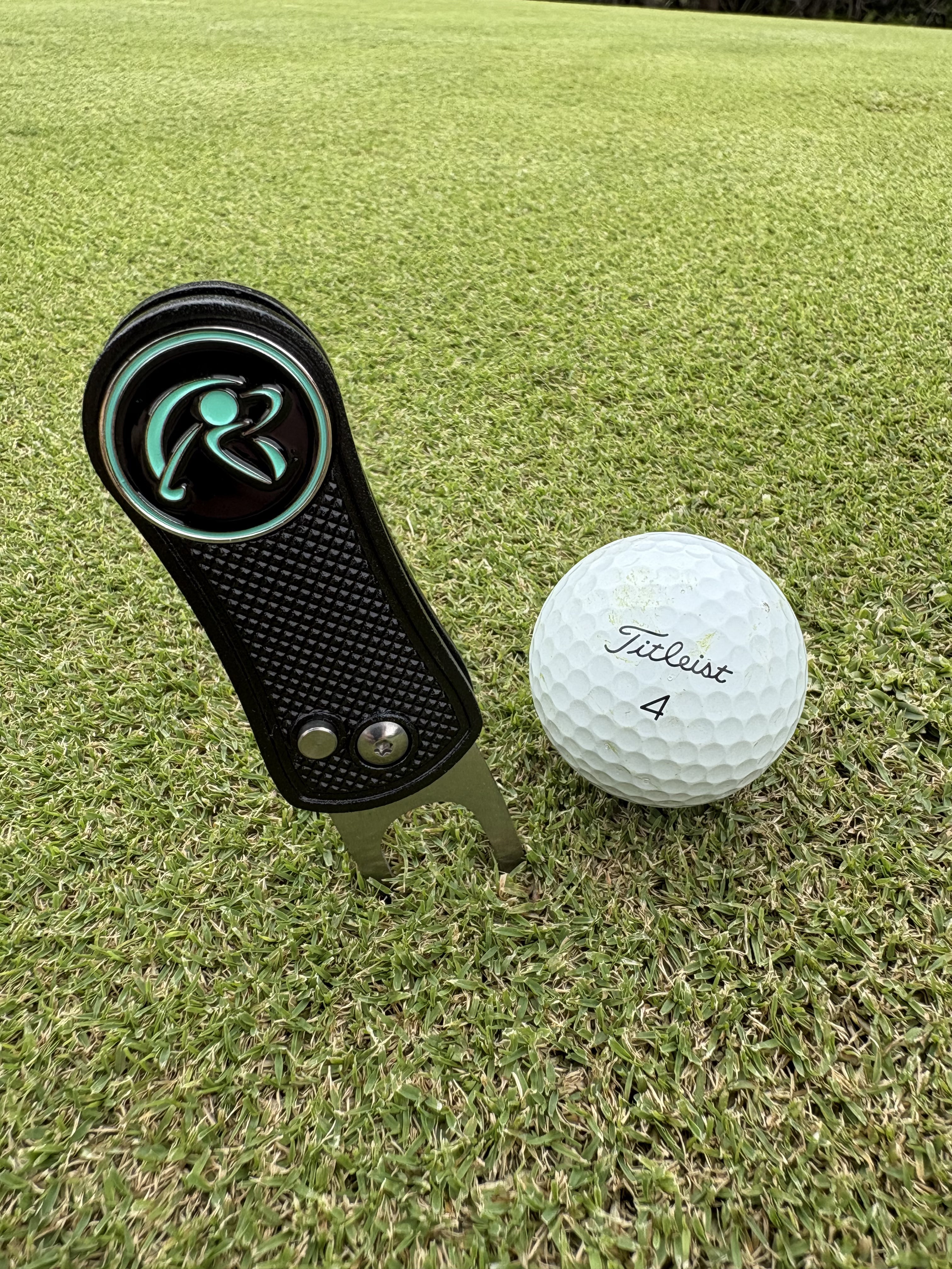 Golf ball and divot tool on a grassy field